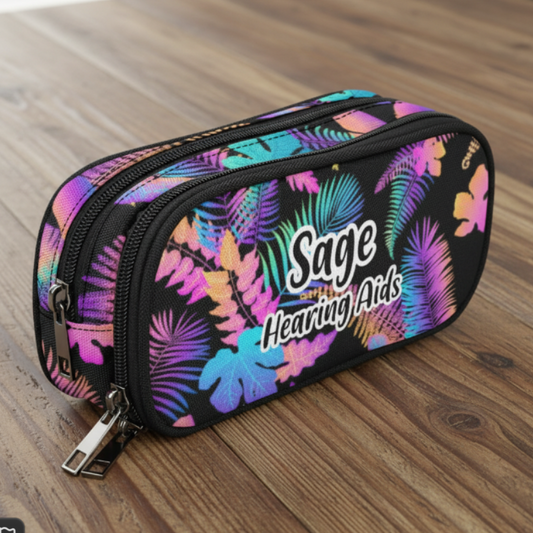 A zippered dual-compartment cochlear implant case with a vibrant tropical leaf pattern in pink, purple, blue, and green on a black background. The front features the text 'Sage Hearing Aids' in white.