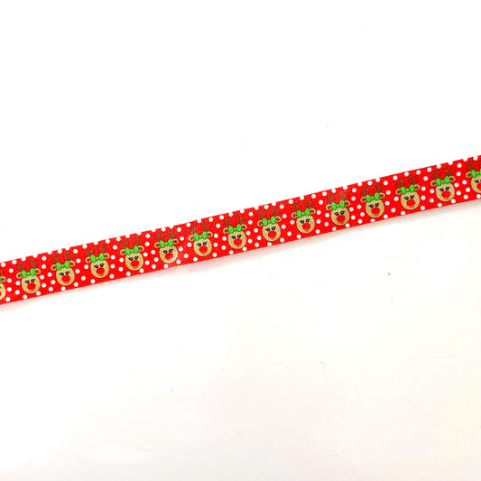 A red ribbon with a pattern of green and white polka dots is shown against a white background.