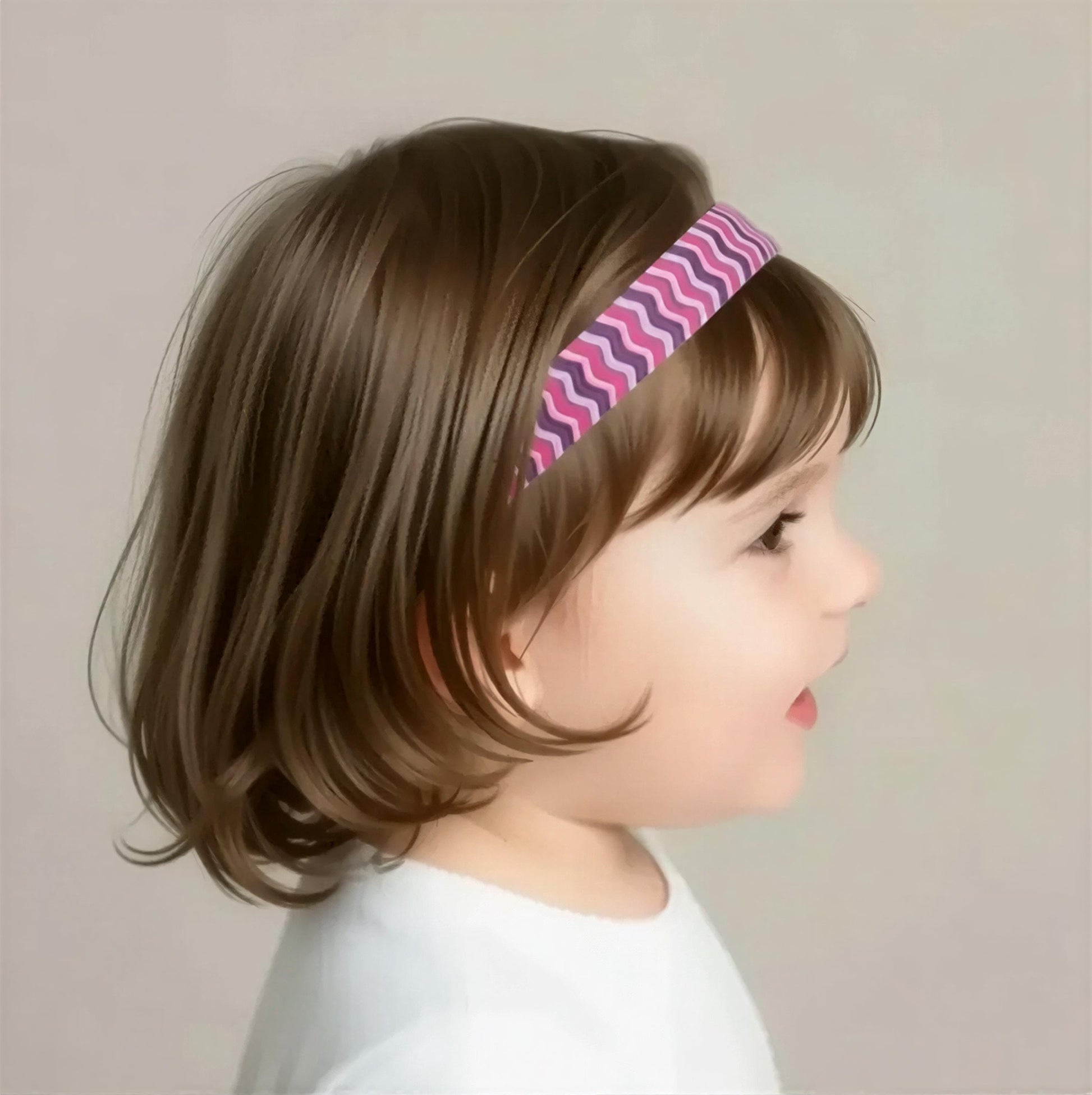 A young girl with brown hair wearing a pink and purple headband is shown in profile against a plain background.