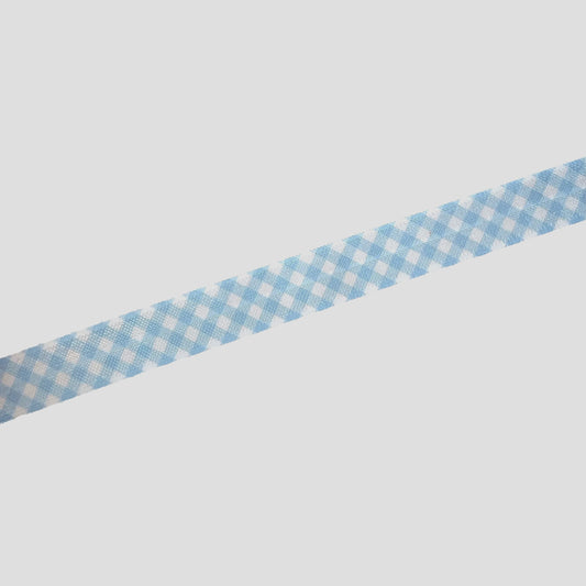 A blue and white checkered ribbon is lying on a white surface.