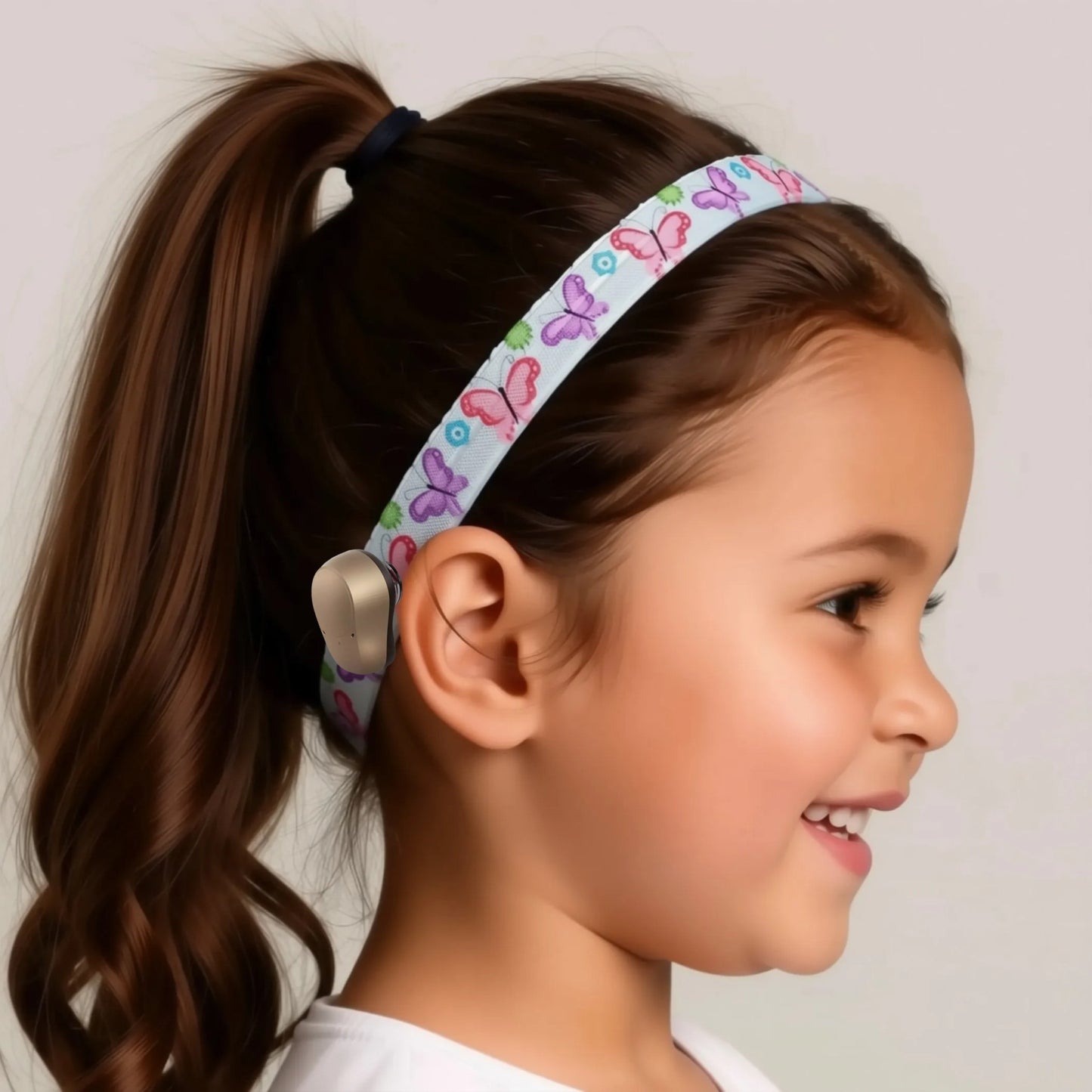 A decorative cochlear implant headband with a repeating pattern of colourful butterflies and flowers.