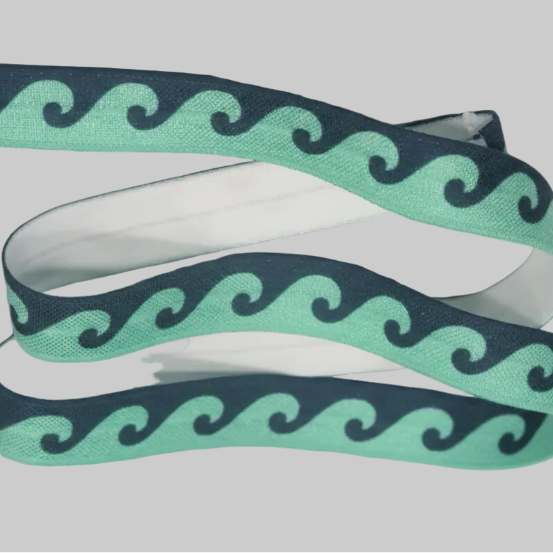 Ponto Baha softband hearing aid headband cochlear implant with a mint green and navy blue wavy pattern.