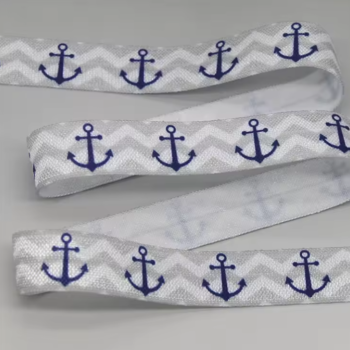Ponto Baha softband hearing aid headband cochlear implant with navy blue anchor motifs, shown in three overlapping loops on a neutral gray background.