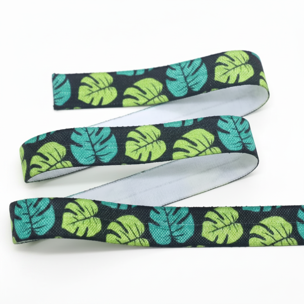Ponto Baha softband hearing aid headband cochlear implant with repeating tropical leaf print in bright green and teal, shown with a white underside.
