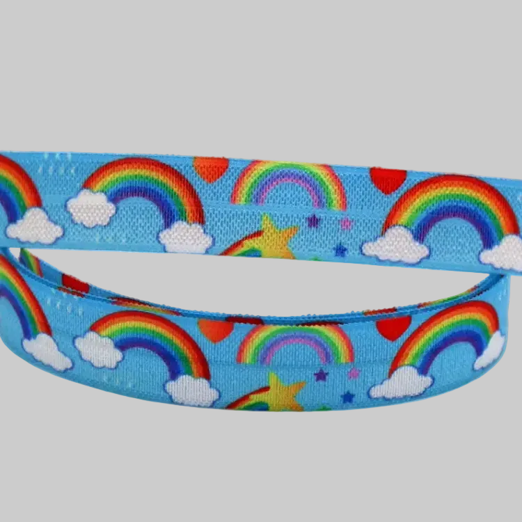 Ponto Baha softband hearing aid headband cochlear implant with a repeating pattern of colourful rainbows, white clouds, and yellow stars.