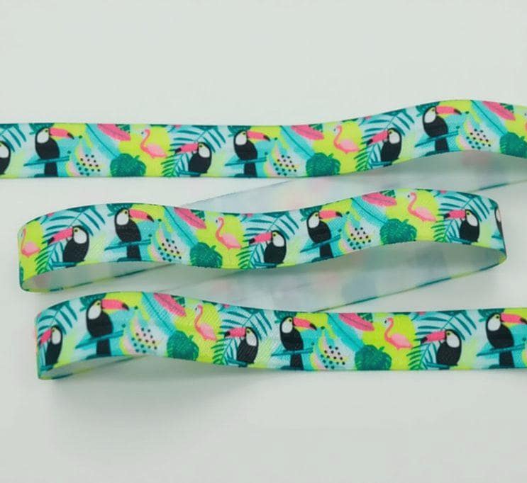 a colorful elastic for cochlear implant headband with a repeating pattern of tropical birds, including toucans, flamingos, and parrots, against a white background.