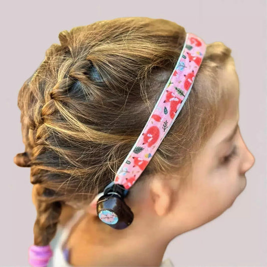 A child wearing a ponto baha softband with a black, shown in profile against a plain light gray background.