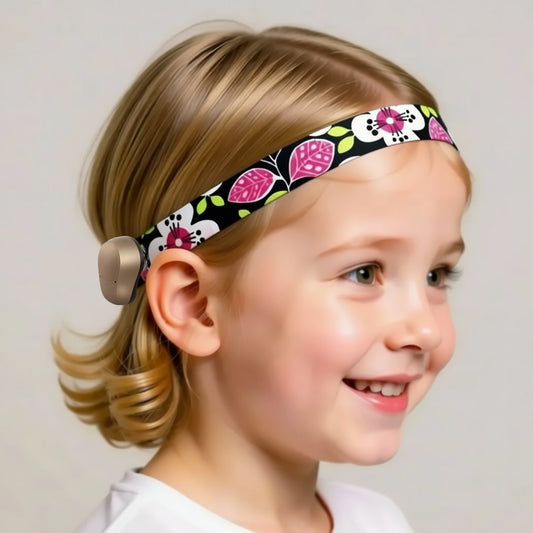 child with a colourful cochlear headband featuring a floral pattern in pink and green.