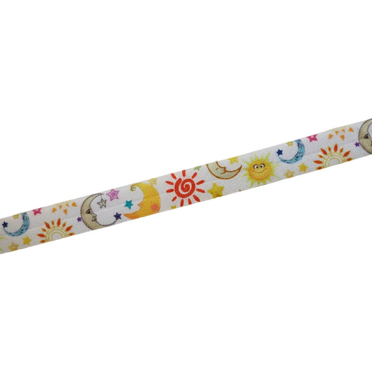 A close-up of a cochlear implant hearing aid headband featuring a colourful cartoon pattern of suns, crescent moons, and stars