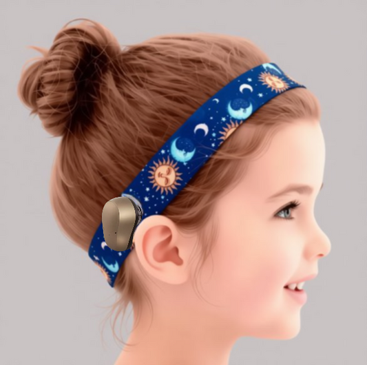 A young girl with a bun hairstyle wearing a blue headband with a pattern of suns and crescent moons.