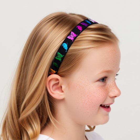 A girl wearing a hearing aid headband with black with colourful butterfly embroidery on it.