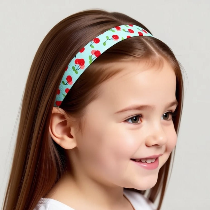 Ponto BAHA cochlear implant hearing aid headband with a repeating pattern of red cherries on a light blue background.