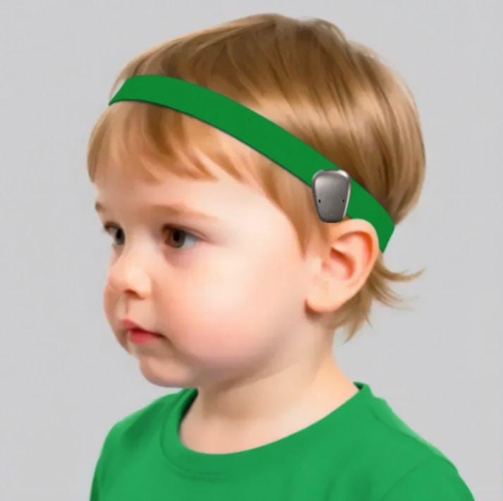 A young child wearing a bright green hearing headband 