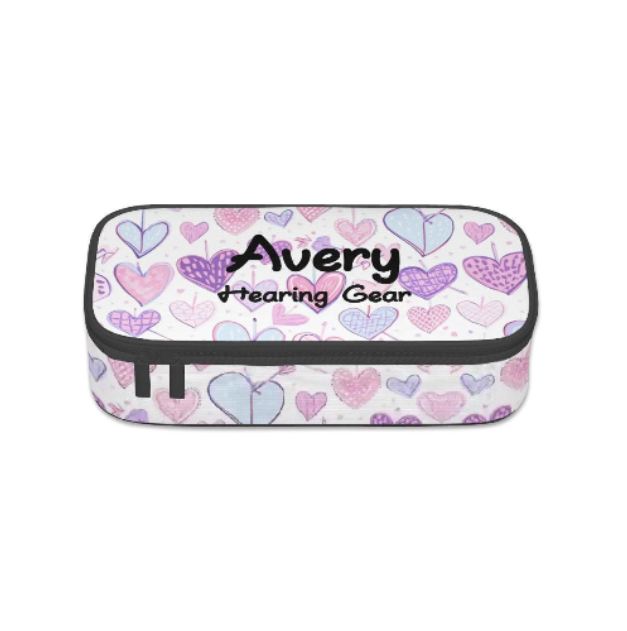 A rectangular zippered storage case for cochlear implant or hearing aids, with a white background covered in a pattern of pink, purple, and light blue hearts. The front features the text 'Avery Hearing Gear' in black script, and the case is finished with black trim and zipper pulls.