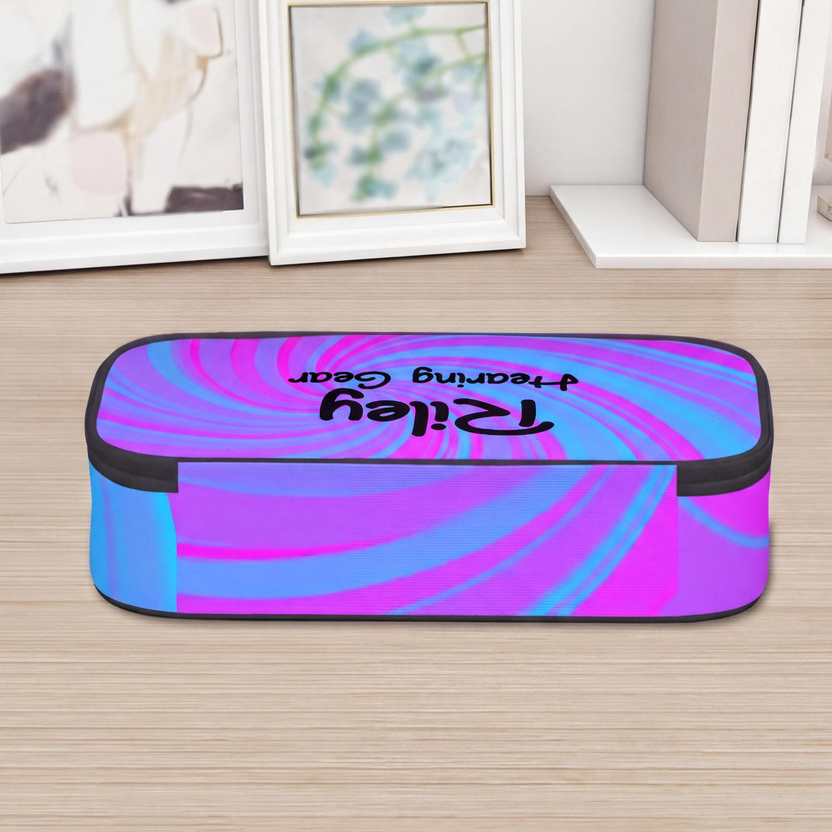 A colourful, spiral-patterned storage case for cochlear implants and hearing aids, on a wooden surface.