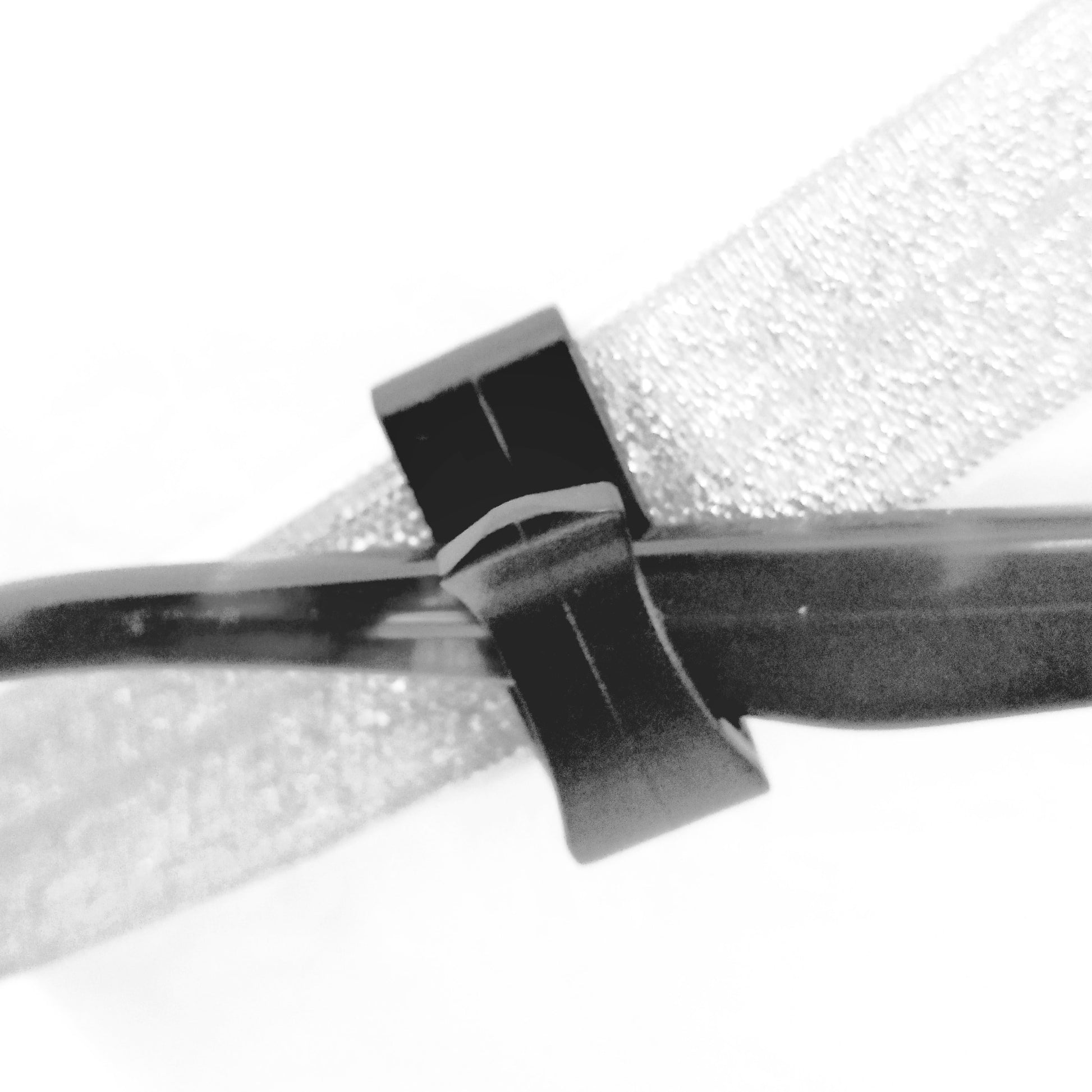 Close-up of a black hair clip on a white background